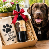 A gift basket with a bottle of Labrador wine and a chocolate Labrador dog in the background.
