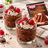 Two-layered Dr Oetker Chocolate Pudding dessert glasses topped with whipped cream and fresh raspberries.