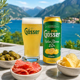 Gösser Lemon beer can and glass with snacks on a scenic background.