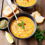 Bowl of lentil stew with dried summer savory, fresh toast and a lemon wedge.