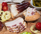 Slices of mangalitsa bacon on bread with tomatoes and peppers.