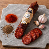 Mangalitsa Salami with slices on a stone board with spices and garlic.
