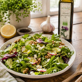 Salad with greens, nuts, and radishes on a wooden table with a bottle of organic milk thistle oil.
