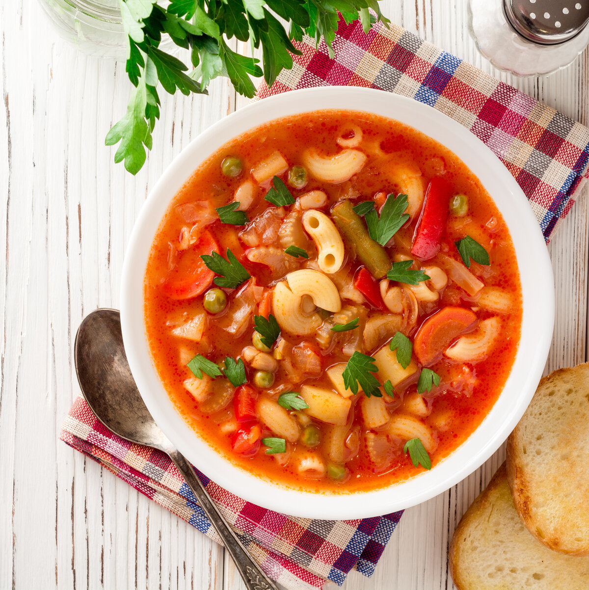 A bowl of minestrone soup made from tomato puree, served with pasta and vegetables.
