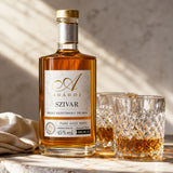 A bottle and two glasses of aszu torkoly palinka, which is a type of pomace brandy fermented from crushed grapes.