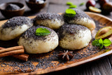 A plate of poppy seed dessert consisting of fresh dumplings topped with a dusting of ground poppy seeds.
