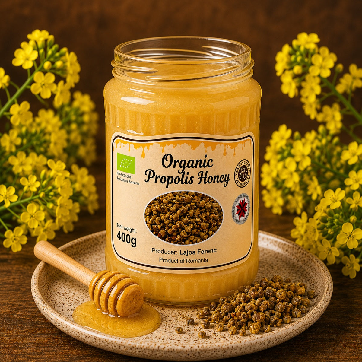 Jar of organic propolis honey with a honey dipper, canola flowers and fresh bee propolis.
