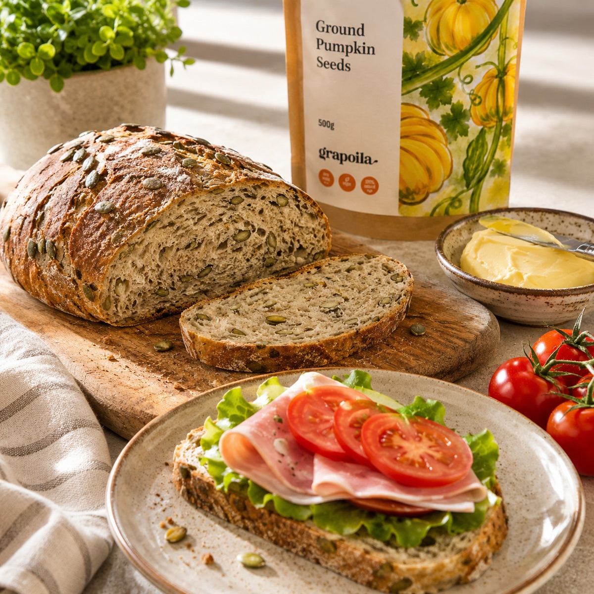 Loaf of pumpkin seed bread with a sandwich on a plate and a bag of ground pumpkin seeds.