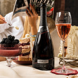 Bottle and glass of Torley rose sparkling wine with a bowl of fruit.