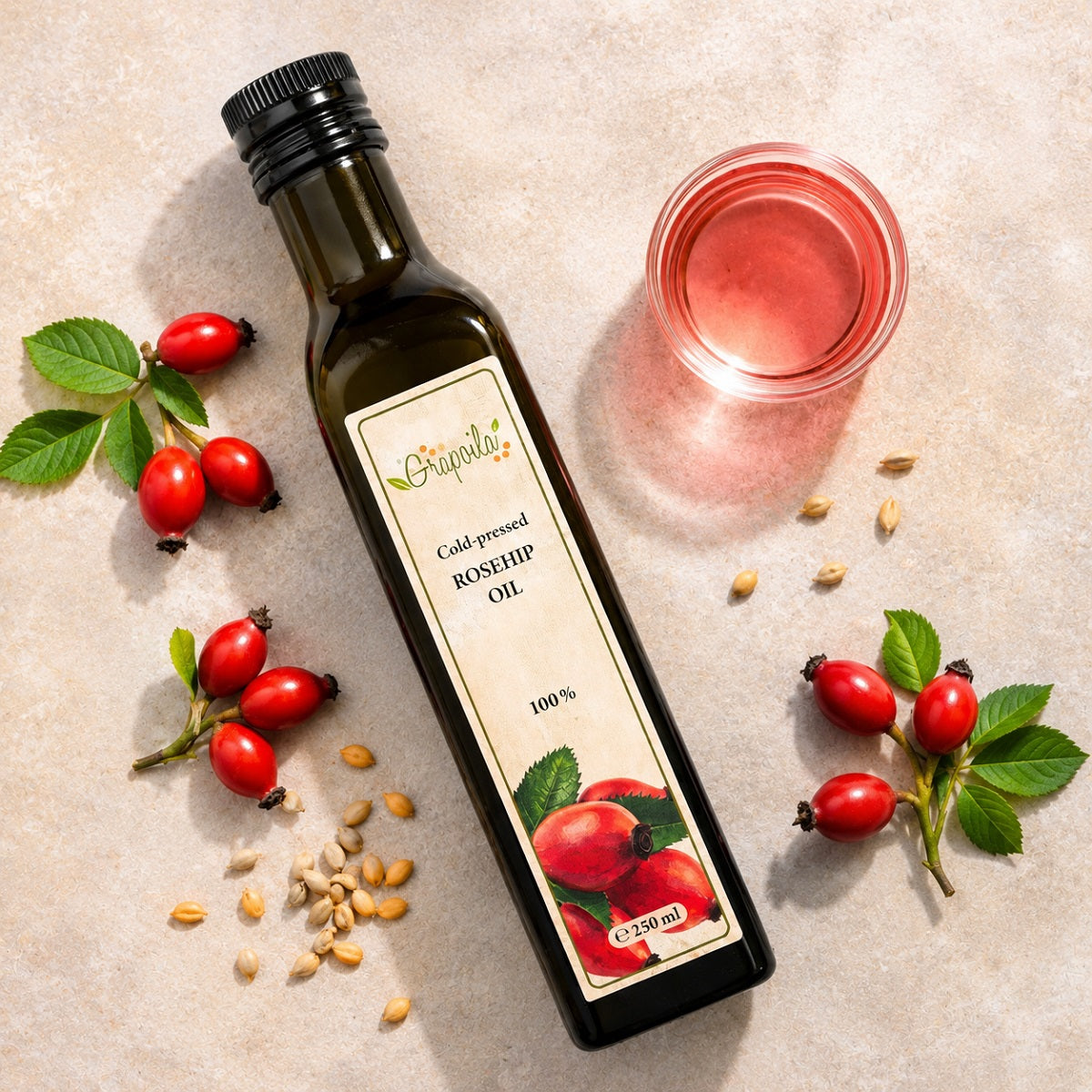 Glass of rosehip oil next to rosehip seeds and red rosehip berries on a light surface