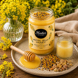Jar of Royal Jelly Honey on a wooden surface with fresh royal jelly, raw propolis and bee pollen granules.