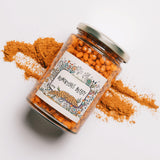 Jar of sea buckthorn berry compote with sea buckthorn powder in the background.