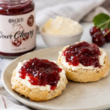 Scones with clotted cream and sour cherry jam on top.