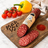 Spicy salami from mangalitza pork on a wooden board with vegetables and spices.
