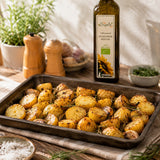 Roasted potatoes on a baking tray with a bottle of sunflower seed oil in the background.