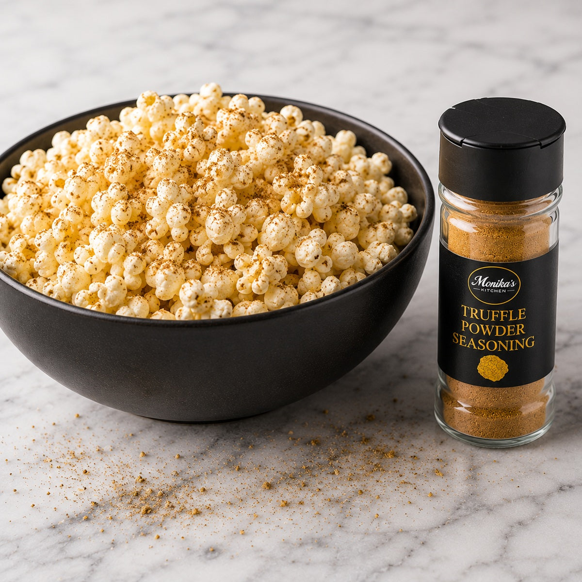 Bowl of popcorn with a bottle of truffle powder seasoning on a marble surface.