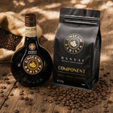 Unicum Barista bottle and a pack of Banyai Barista coffee on a wooden surface with coffee beans.
