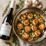 Frying pan with scallops in a verjus sauce made with butter and garlic.