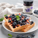 Waffles with low-sugar blueberry jam and pieces of fresh fruit on top.