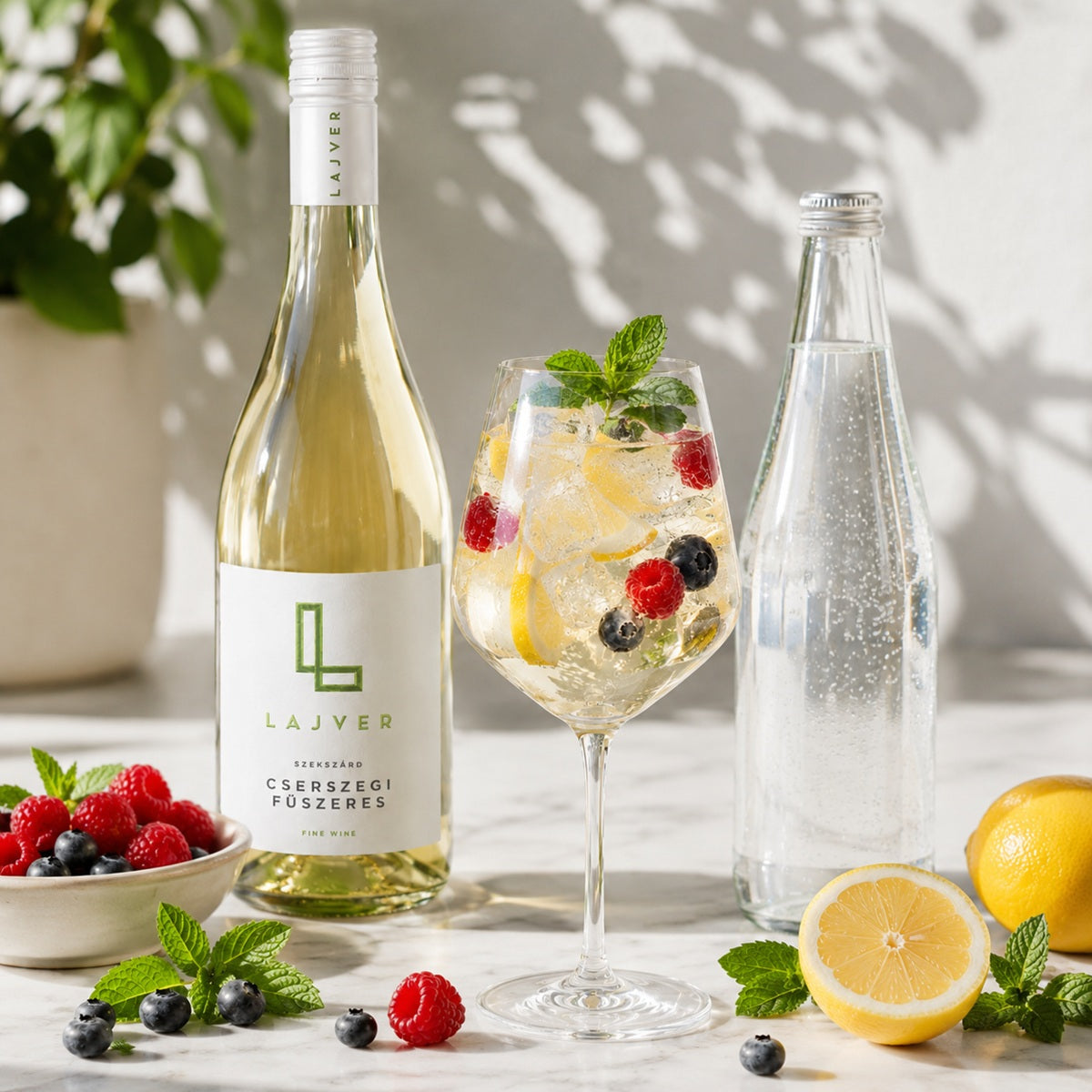A glass of white wine spritzer made with soda water and Cserszegi Fűszeres wine, served with berries and mint.