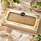 Acacia honeycomb frame gift box styled with ribbon, acacia blossoms and a blank gift tag.