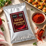Hungarian Sweet Smoked Paprika 500g pouch lying flat beside roasted vegetables and paprika powder.