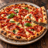 Homemade pizza topped with Kulen salami, roasted red peppers and mozzarella.