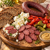 Bosnian sujuk with rye bread, white cheese, pickles and roasted peppers.