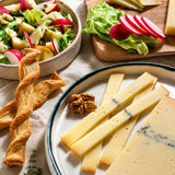 Artisan ash cheese on a plate with crackers and walnuts.