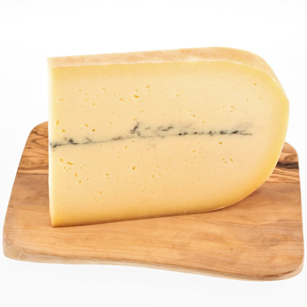 A wedge of ash cheese, this artisan cow's cheese has an ash line in the middle.