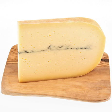 A wedge of ash cheese, this artisan cow's cheese has an ash line in the middle.