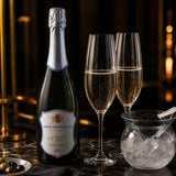 Glass caviar bowl with fresh caviar on ice, paired with a bottle of Champagne.