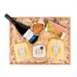 A deluxe cheese and wine hamper with a selection of cheese, chutney, crackers and a bottle of red wine.